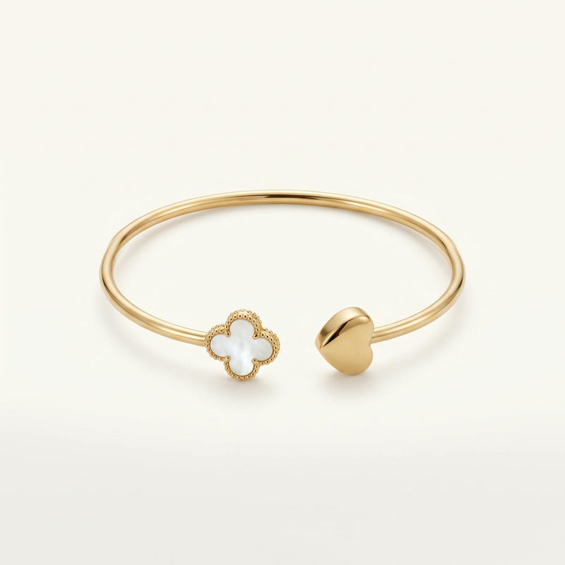Bracelet jonc ouvert doré avec trefle en nacre et coeur sur fond ivoire