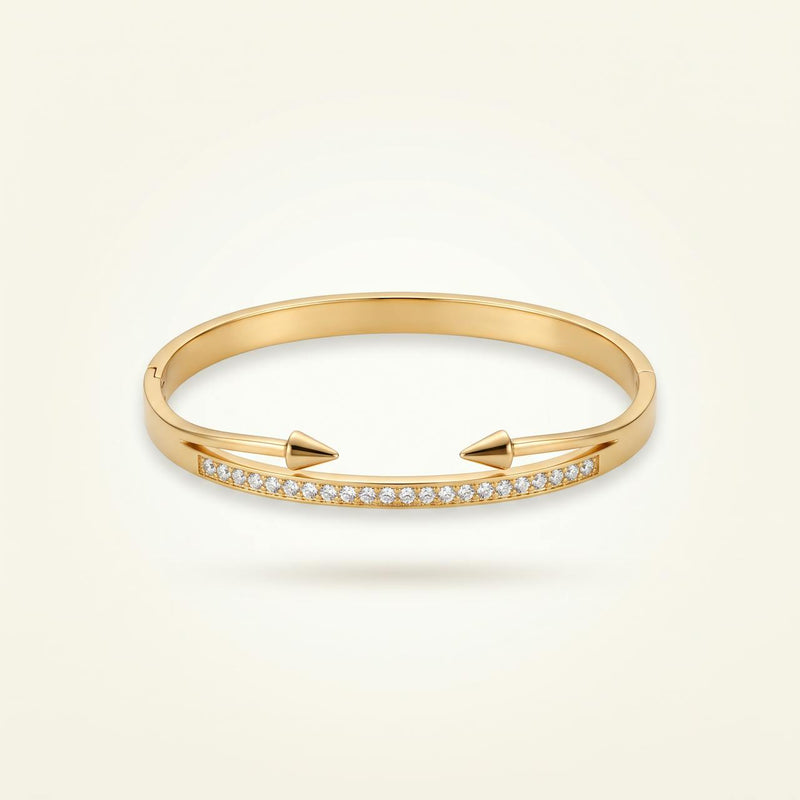 Bracelet jonc doré à pointes avec ligne de pierres sur fond ivoire