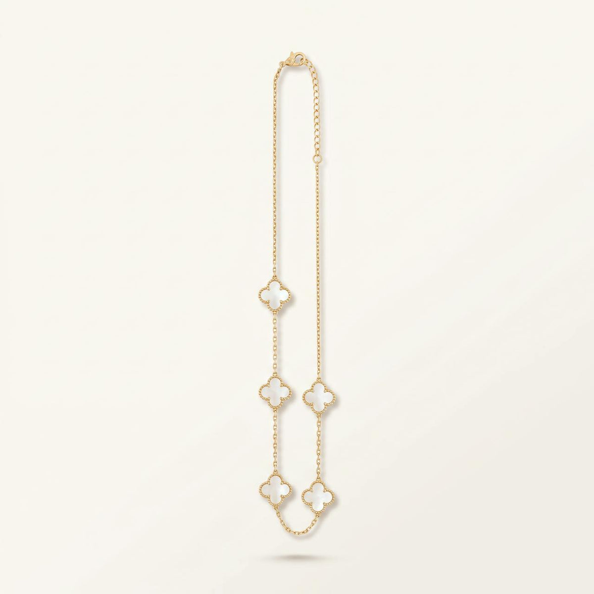 Collier doré à cinq trèfles en nacre blanche sur fond ivoire