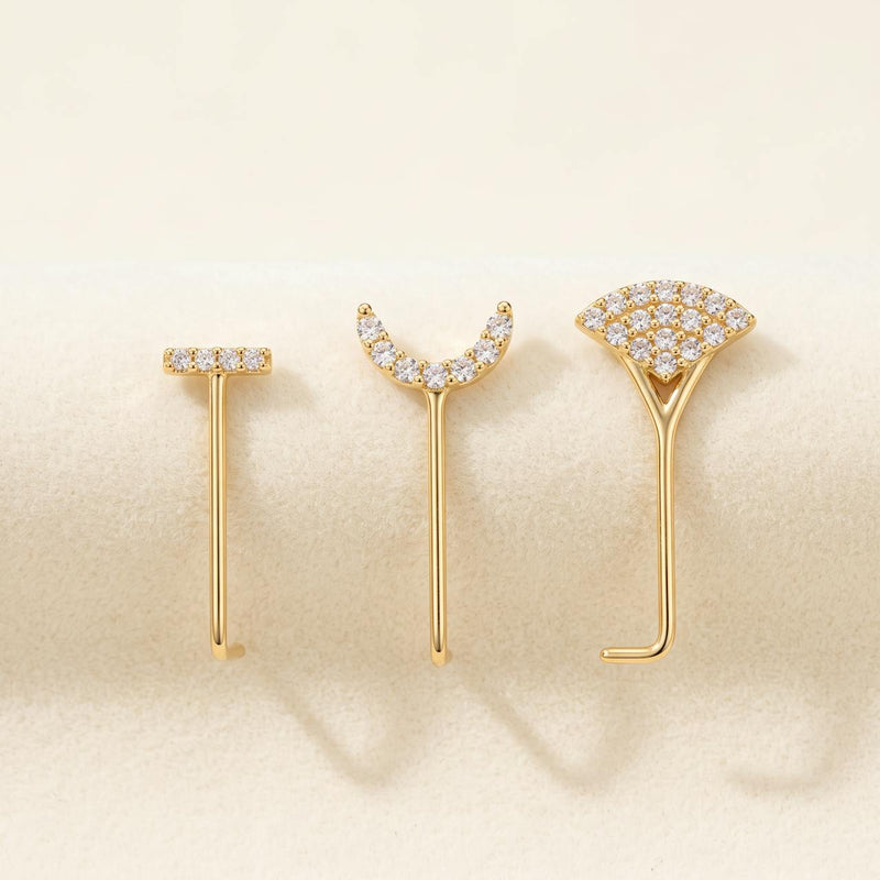 Pack de trois piercings dorés : barrette sertie, arc de pierres et éventail, sur fond ivoire